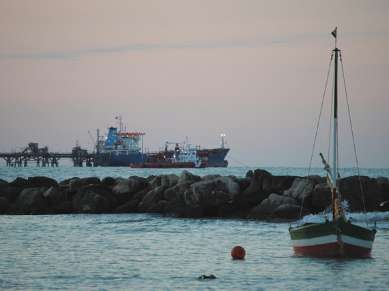 un molo al tramonto con alcune imbarcazioni ormeggiate