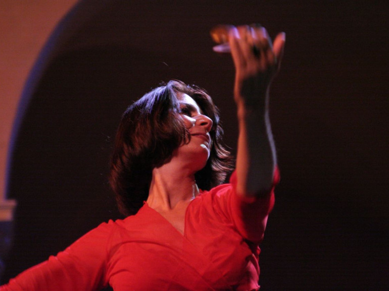 una ballerina vestita di rosso con nacchere in mano