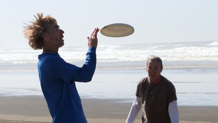 due signori fanno freestyle frisbee in spiaggia