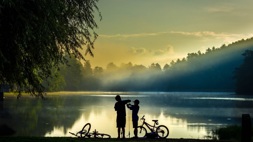 bambini e biciclette in riva ad un lago