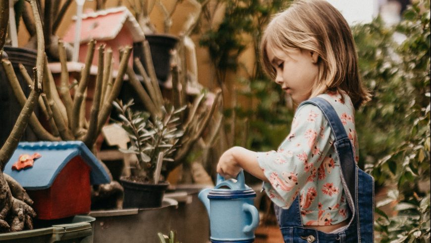 bambina che innaffia le piante