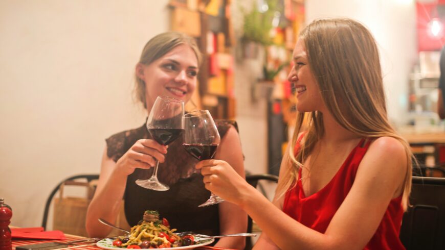 Foto con due donne che brindano con un calice di vino
