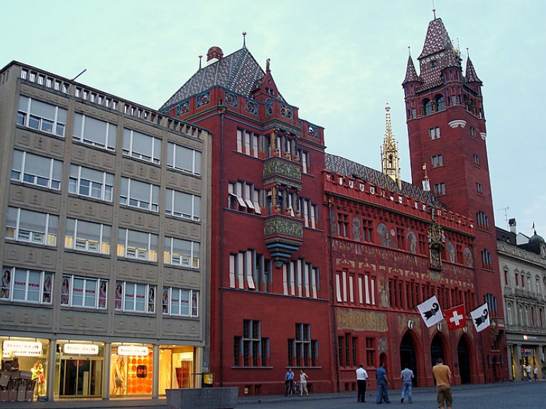 palazzo in pietra rossa con torre e guglie