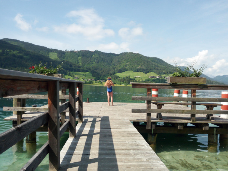 Una bambina sta per tuffarsi nelle acque limpide del lago di Weissensee