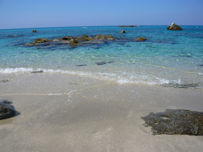 una baia di sabbia su un mare azzurro cristallino