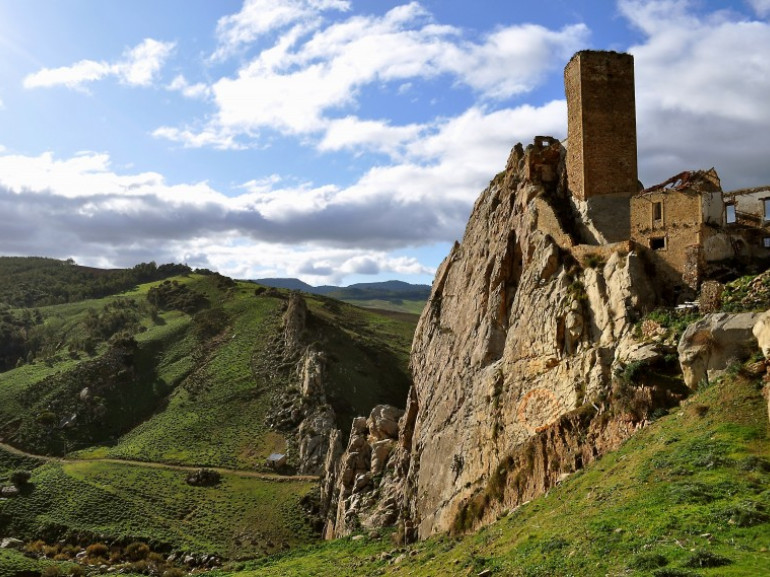 antichi resti di un castello in pietra arroccato ad una paretete rocciosa su una collina. In particolare si erge una torre ancora ben conservata