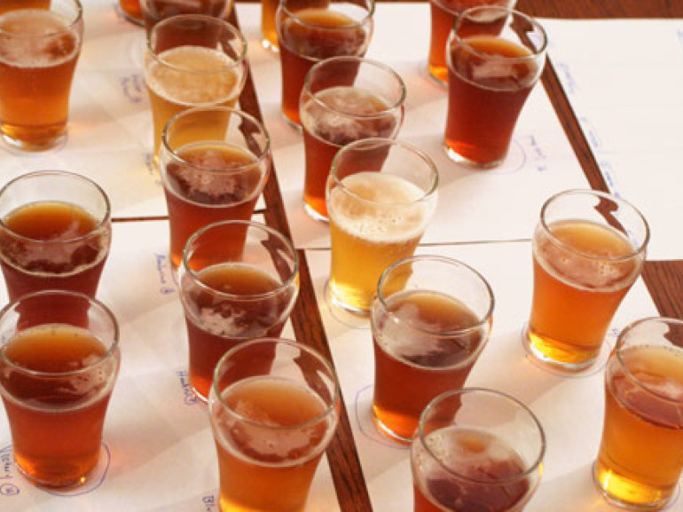 diversi bicchieri su un tavolo ciascuno pieno di diversi tipi di birra