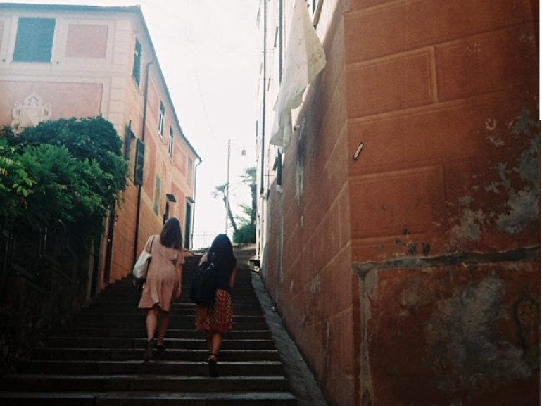 Due ragazze salgono una scalinata tra i palazzi del centro storico di Camogli