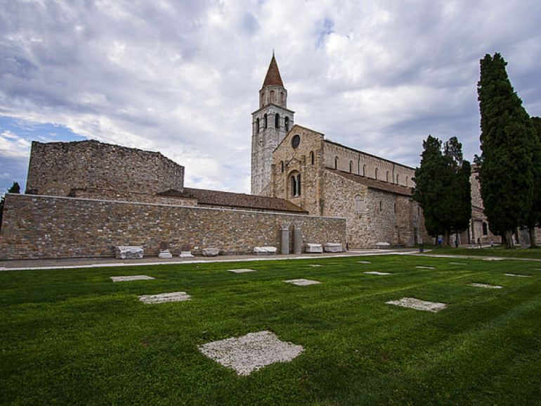 La chiesa di aquileia e il vicono cimitero. Attorno un prato verde
