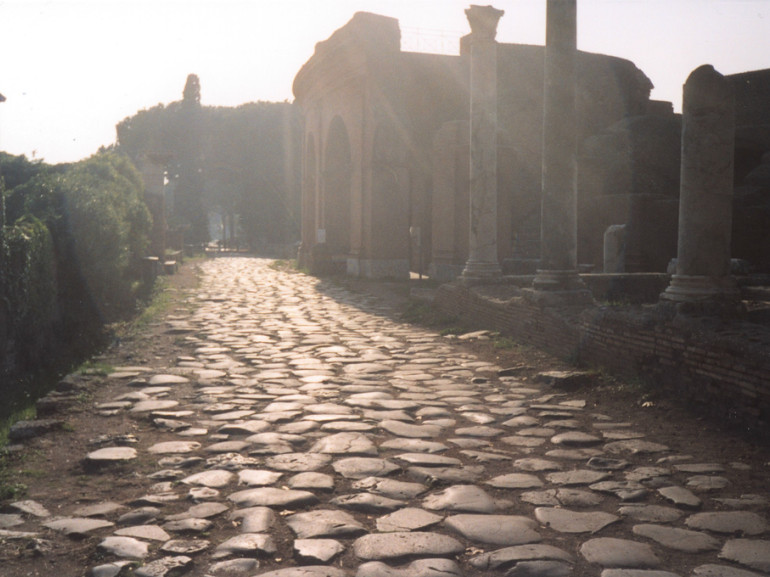 una strada lastricata di grosse pietre e resti antichi