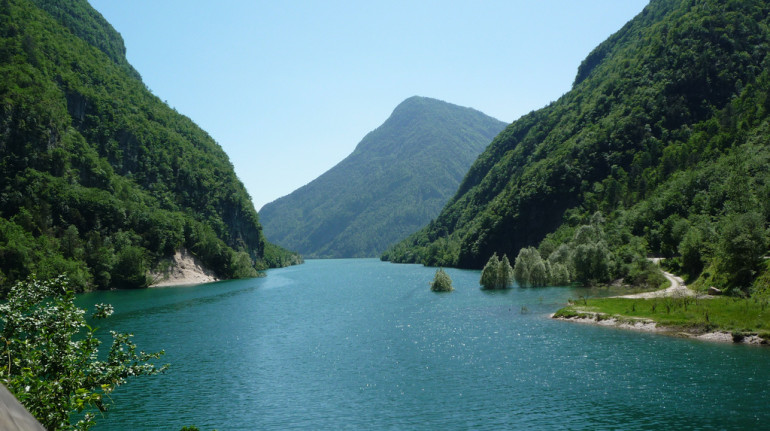 scorcio del lago circondato da montagne e boschi