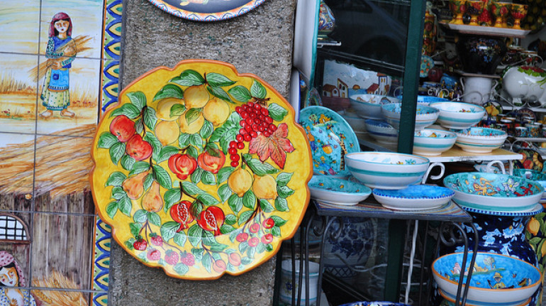 Alcuni piatti in ceramica colorata appesi fuori da un negozio